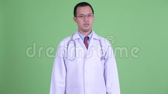 悲伤的亚洲男子医生戴着眼镜竖起大拇指视频的预览图