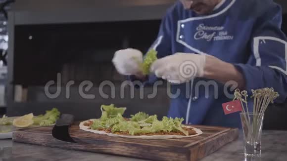 熟练的厨师制服准备美味的盘子包裹在拉瓦什厨师手拿白橡胶手套撕生菜视频的预览图