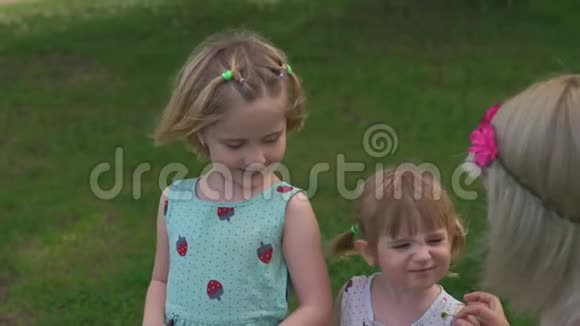 年轻的金发嬉皮士妈妈和她的女孩子在公园里跳舞她们穿着类似的衣服视频的预览图
