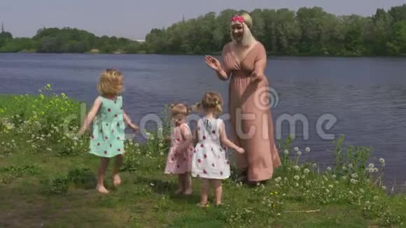 年轻的金发嬉皮士妈妈和她的小女孩在公园里跳舞女儿穿着类似的衣服视频的预览图
