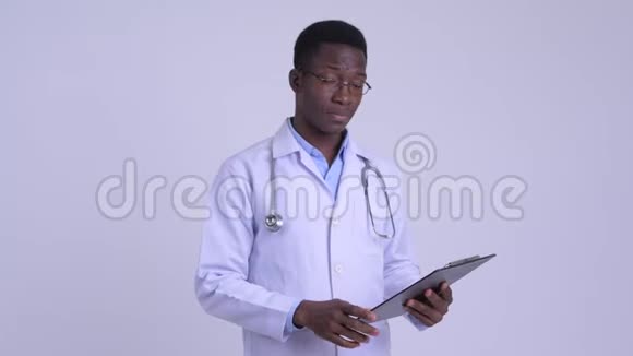 年轻时压力很大的非洲男子医生在剪贴板上看书竖起大拇指视频的预览图