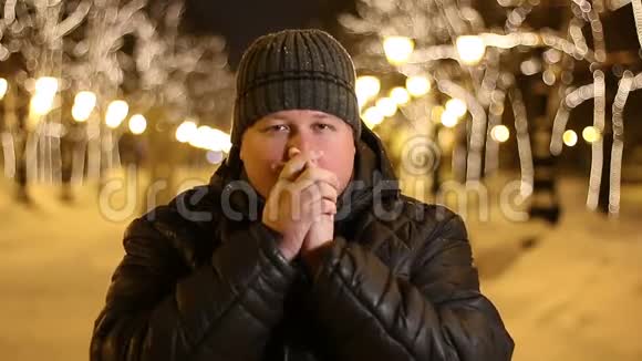 在冬天的夜晚人们在户外暖和暖手视频的预览图