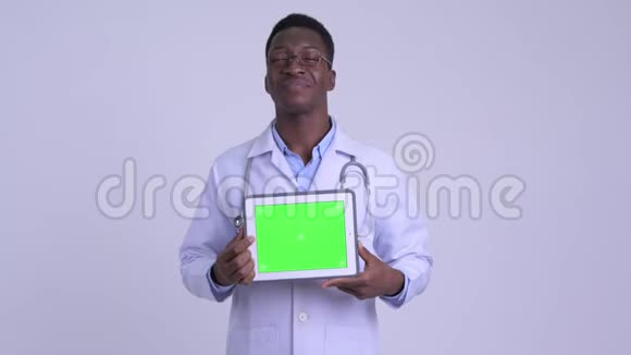 年轻快乐的非洲男子医生一边思考一边展示数字平板视频的预览图