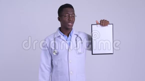 年轻的压力很大的非洲男子医生展示剪贴板竖起大拇指视频的预览图
