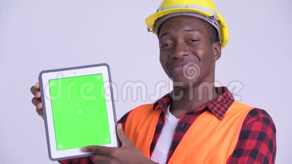 年轻快乐的非洲建筑工人展示数字平板电脑的脸视频的预览图
