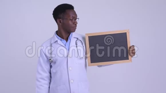 年轻快乐的非洲男医生拿着黑板竖起大拇指视频的预览图