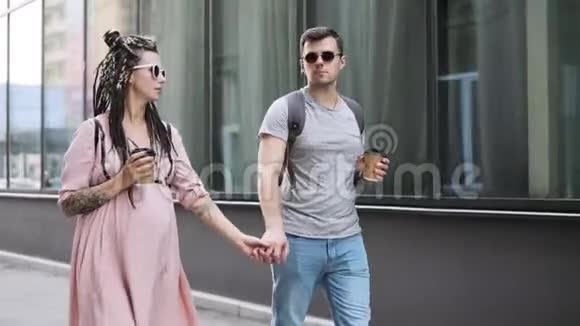 几个时髦的男人和孕妇牵着手在城里散步视频的预览图