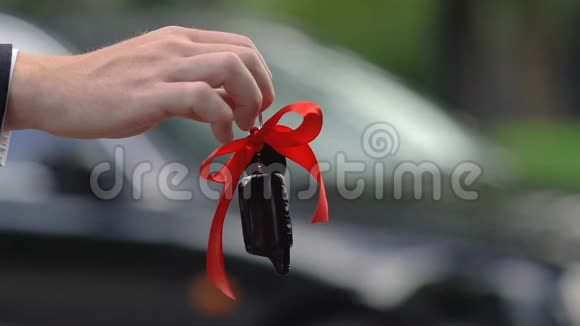 女人从经销商手里拿着红丝带的车钥匙买车租房视频的预览图