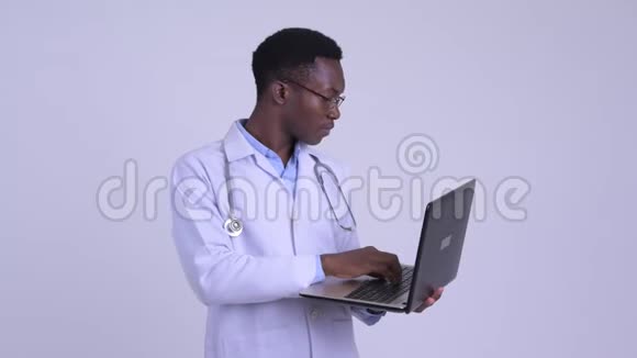 年轻快乐的非洲男子医生使用笔记本电脑得到好消息视频的预览图