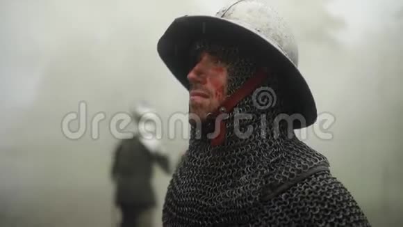 中世纪骑士穿着盔甲在雾蒙蒙的森林里雨的肖像视频的预览图
