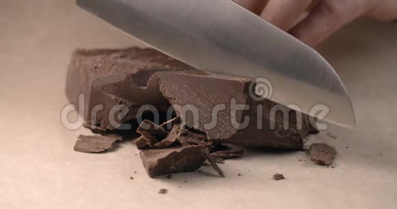 小块巧克力的厨师用小刀慢慢切用巧克力烹饪甜糕点糖果视频的预览图