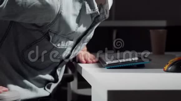 一个人在电脑前坐在椅子上开始工作时被人打了弯视频的预览图