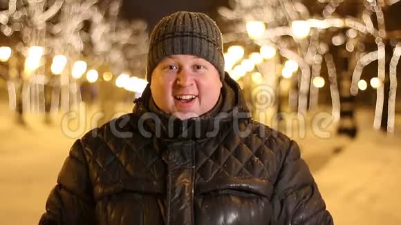 令人惊讶的英俊男子在寒冷的冬夜在户外庆祝的画像视频的预览图