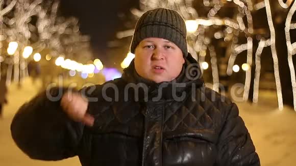 冬天寒冷的夜晚悲伤的男人在户外展示拇指的肖像视频的预览图