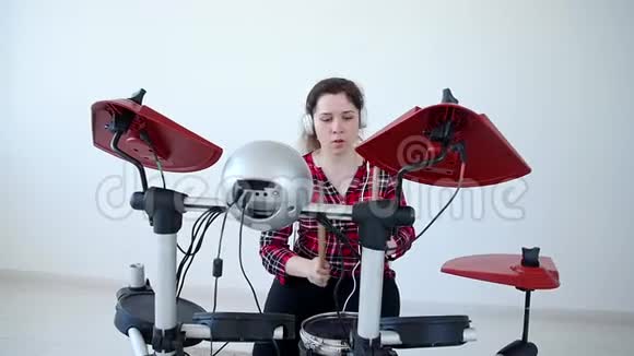 爱好和音乐的概念年轻女子在家练习电子鼓包视频的预览图