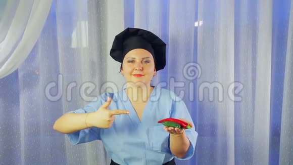 女人穿着围裙做饭微笑着手里拿着辣椒指着它们视频的预览图