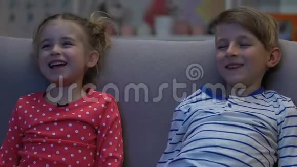兄妹俩看滑稽的真人秀父母睡觉时大笑视频的预览图