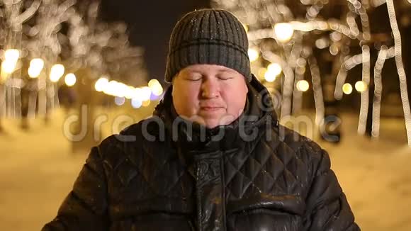 冬天寒冷的夜晚在户外头痛的悲伤男人的肖像视频的预览图