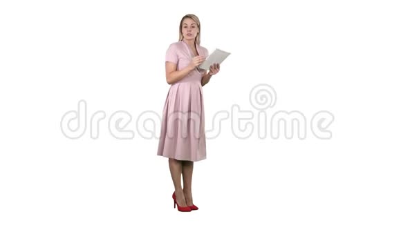 穿着粉红色衣服的女青年女士站着拿着平板电脑在白色背景上给相机演讲视频的预览图