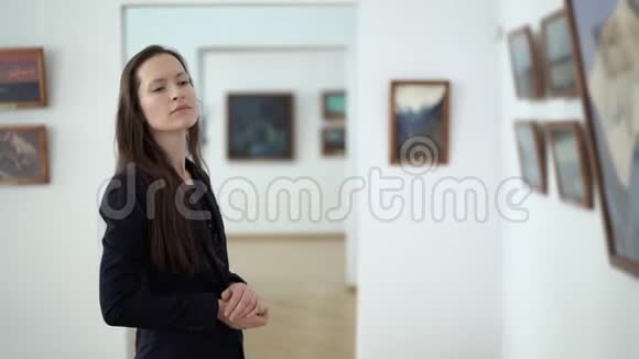 在艺术开幕招待会上优雅的美女看着画廊里的画现代博物馆的图片视频的预览图