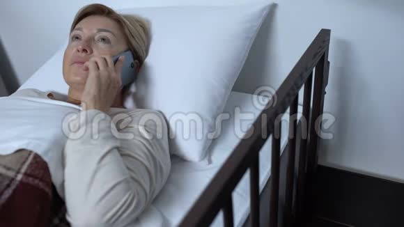 严格的护士对躺在病床上的女性病人的手机不尊重视频的预览图