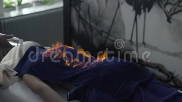 在中国的一次火灾按摩中一名男子将液体倒在一块毛巾上点燃了躺在床上的人锅左视频的预览图