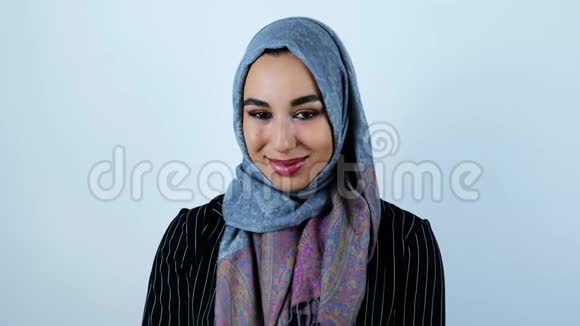 年轻美丽的阿拉伯女人微笑着在与世隔绝的白色背景下感到有点害羞视频的预览图
