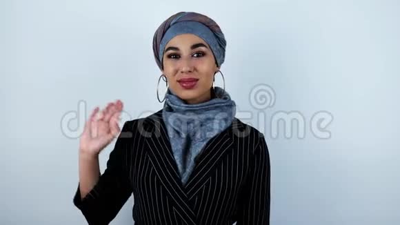 年轻美丽的阿拉伯女人挥舞着她的手在孤立的白色背景上微笑视频的预览图