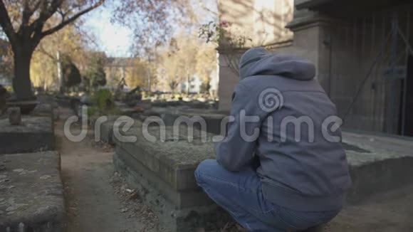 悲伤的人在古墓园的墓旁祈祷纪念家族世代视频的预览图