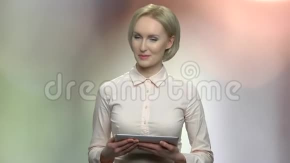 手持数码平板电脑的中年女性扬声器视频的预览图