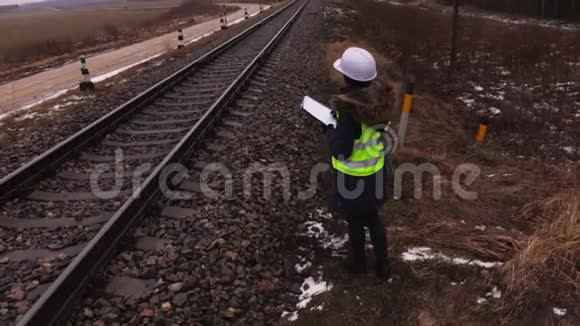 女铁路员工在铁路附近写作视频的预览图