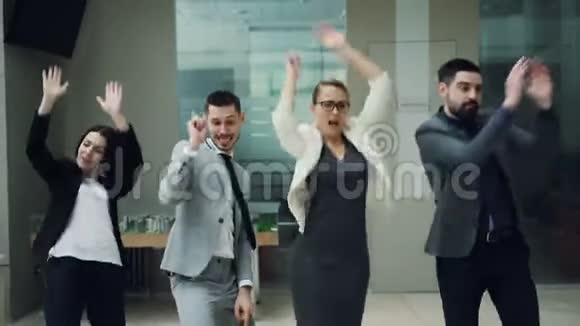 快乐的商业团队男人和女人在工作聚会上跳舞一起移动身体欢笑和歌唱放松视频的预览图