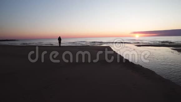 年轻女子沿着海滩散步看日落和海水拉脱维亚图亚2019年4月13日视频的预览图