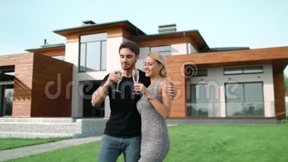 快乐的一对夫妇一起喝香槟在豪华的家附近视频的预览图