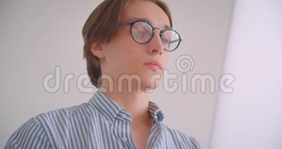 一位年轻有魅力的高加索商人在笔记本电脑上工作看着坐在电脑里的照相机的特写照片视频的预览图