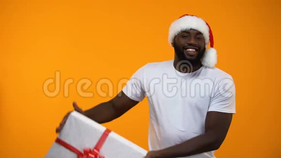 圣诞老人拿着礼品盒和眨眼节日折扣买礼物的时间视频的预览图