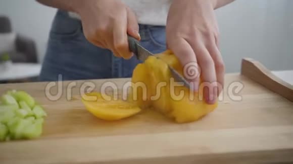 用锋利的刀在厨房的桌子上切大黄番茄的女性手特写健康观念视频的预览图