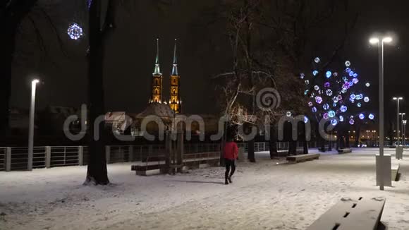 美丽的降雪波兰沃茨劳的白冬圣约翰大教堂有圣诞灯的街道视频的预览图