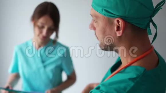 工作的医务人员实习生和医生在门诊走廊咨询穿着医用礼服的男女视频的预览图