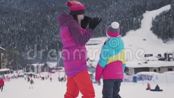 在滑雪场和妈妈在一起的小女孩幸福的家庭在山上享受寒假视频的预览图