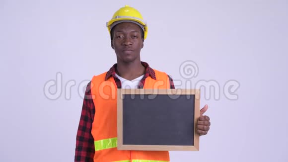 年轻快乐的非洲男子建筑工人拿着黑板竖起大拇指视频的预览图