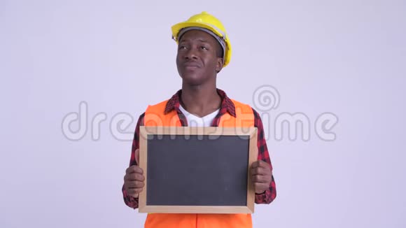 年轻快乐的非洲人建筑工人拿着黑板思考视频的预览图