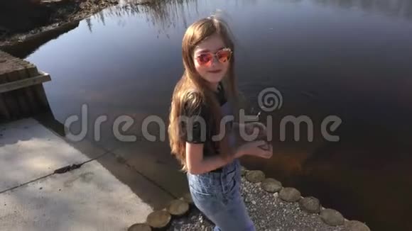 快乐的小女孩在湖里扔石头视频的预览图