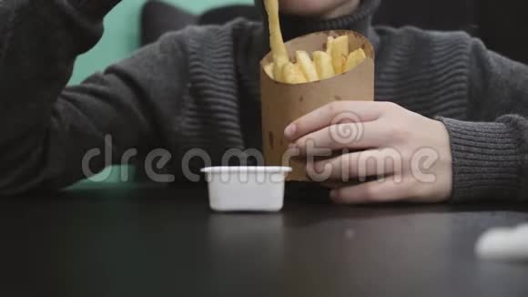 男孩在快餐店吃炸薯条加酱汁快餐健康饮食理念视频的预览图