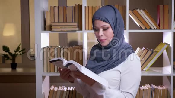 穆斯林成年女学生戴头巾在图书馆看书接受医学教育的特写镜头视频的预览图