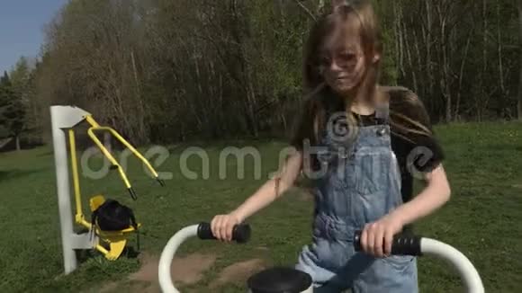 小女孩在公园的训练机上做腿操视频的预览图