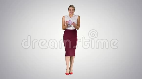 美丽的年轻商务女性显示钱在凸轮梯度背景视频的预览图