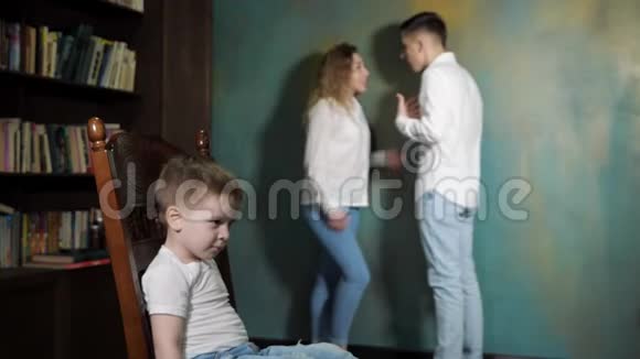 悲伤的小男孩正在听离婚父母的争吵视频的预览图