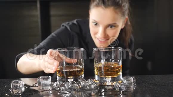 夜总会里的夜生活女酒保在酒杯里准备酒精鸡尾酒使冰块缓慢运动冰冰视频的预览图