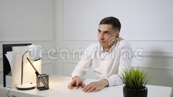 办公室员工年轻人在办公室桌子上坐着拖延时间视频的预览图